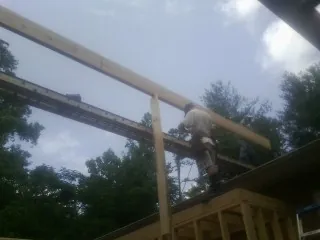 Carpenter setting a ridge beam over a new addition frame — Ice Dam Removal by Roofing Brothers in Gloucester City
