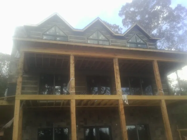 Dormers and porch framing on a large log home under construction — Roof Coating work by our crew in Gloucester City