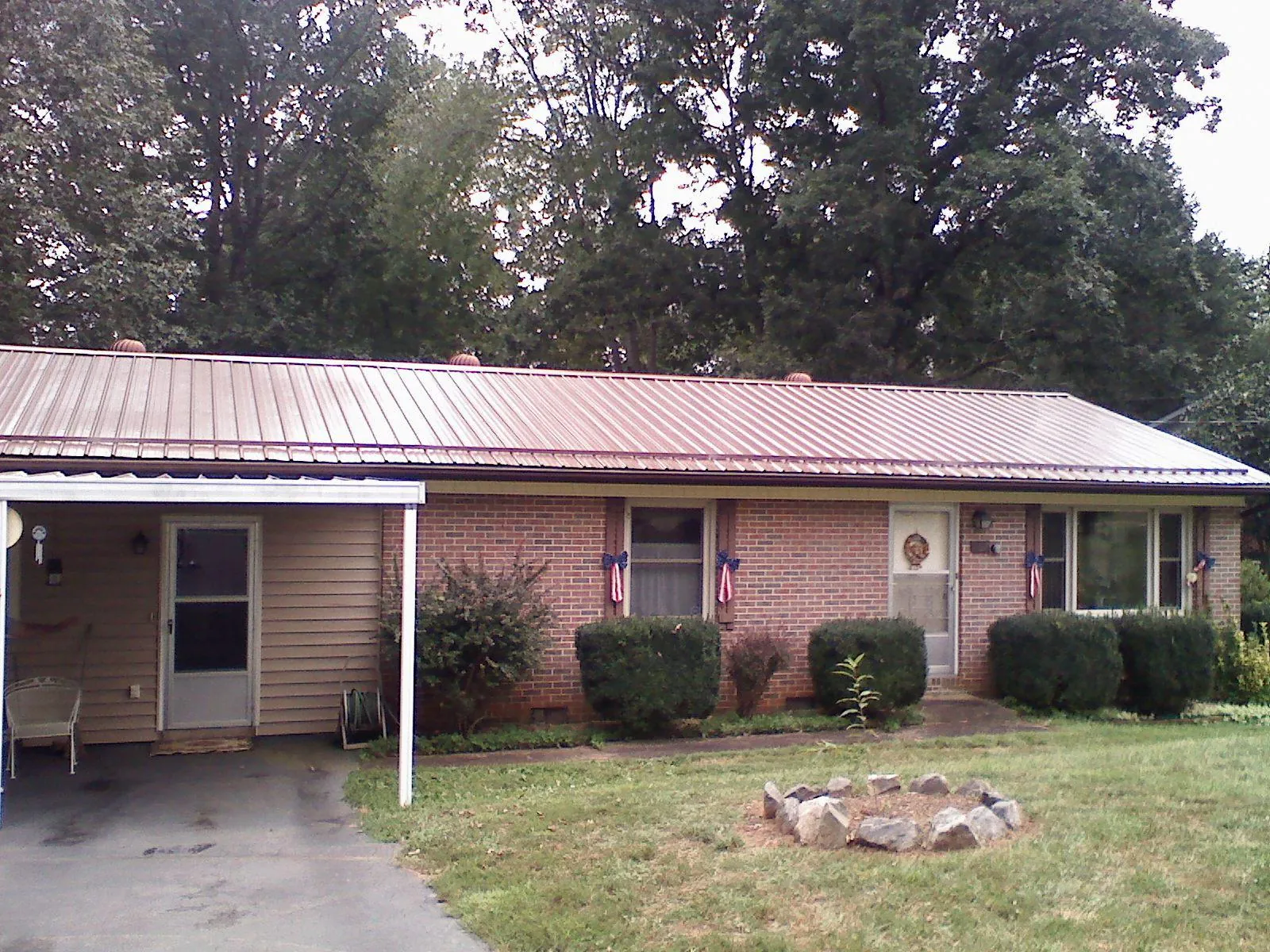 Bronze metal roof and carport on a brick ranch home — Roof Repair work by our crew in Gloucester City